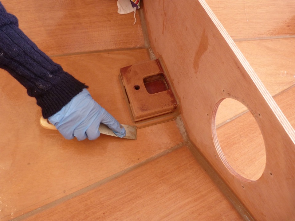 Nettoyage des excédents d'époxy chargée sur les bords du petit joint-congé autour du pied de mât. 