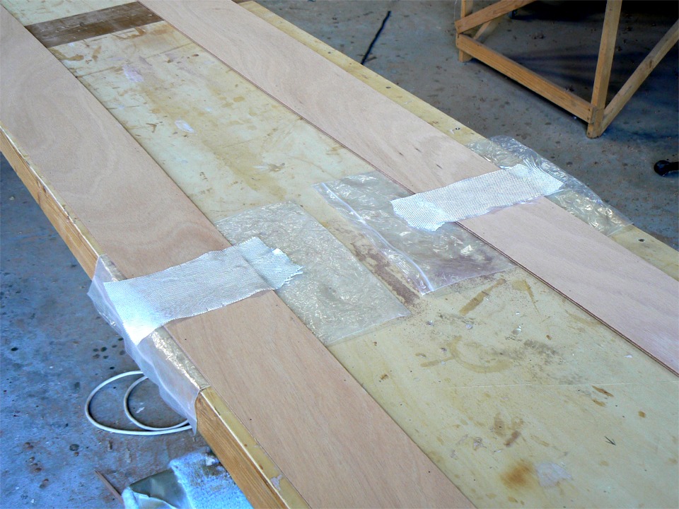 Préparation du collage des joints-puzzle des panneaux latéraux du Shearwater. Les joints sont renforcés par une longueur de bande de fibre de verre. 